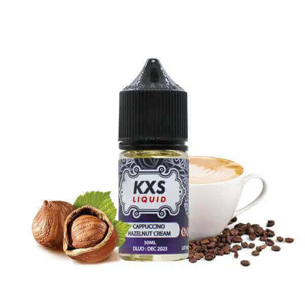 Flacon d'arôme concentré KXS Liquid 30ml Cappuccino Hazelnut Cream avec noisettes et tasse de café en arrière-plan.